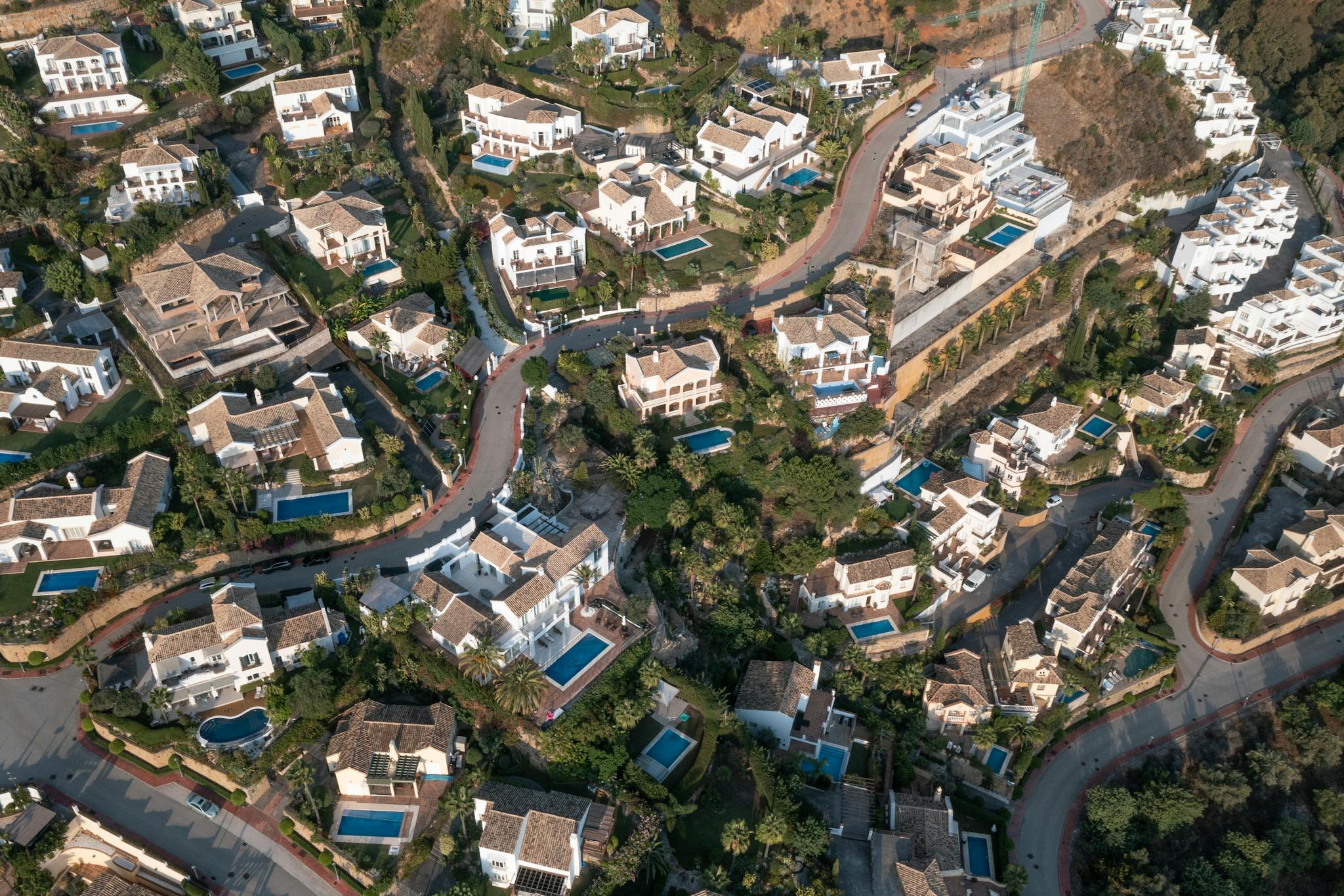 Aerial view showcasing a picturesque suburban area in Spain with elegant homes and pools.