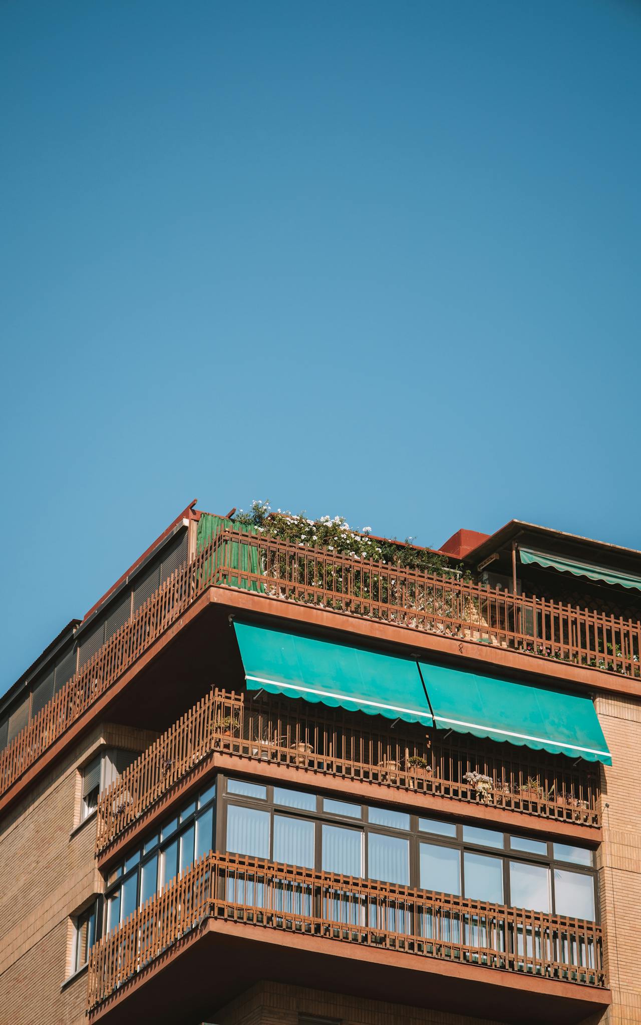 Top view of a modern apartment building in Málaga, Spain with distinctive balconies and greenery.